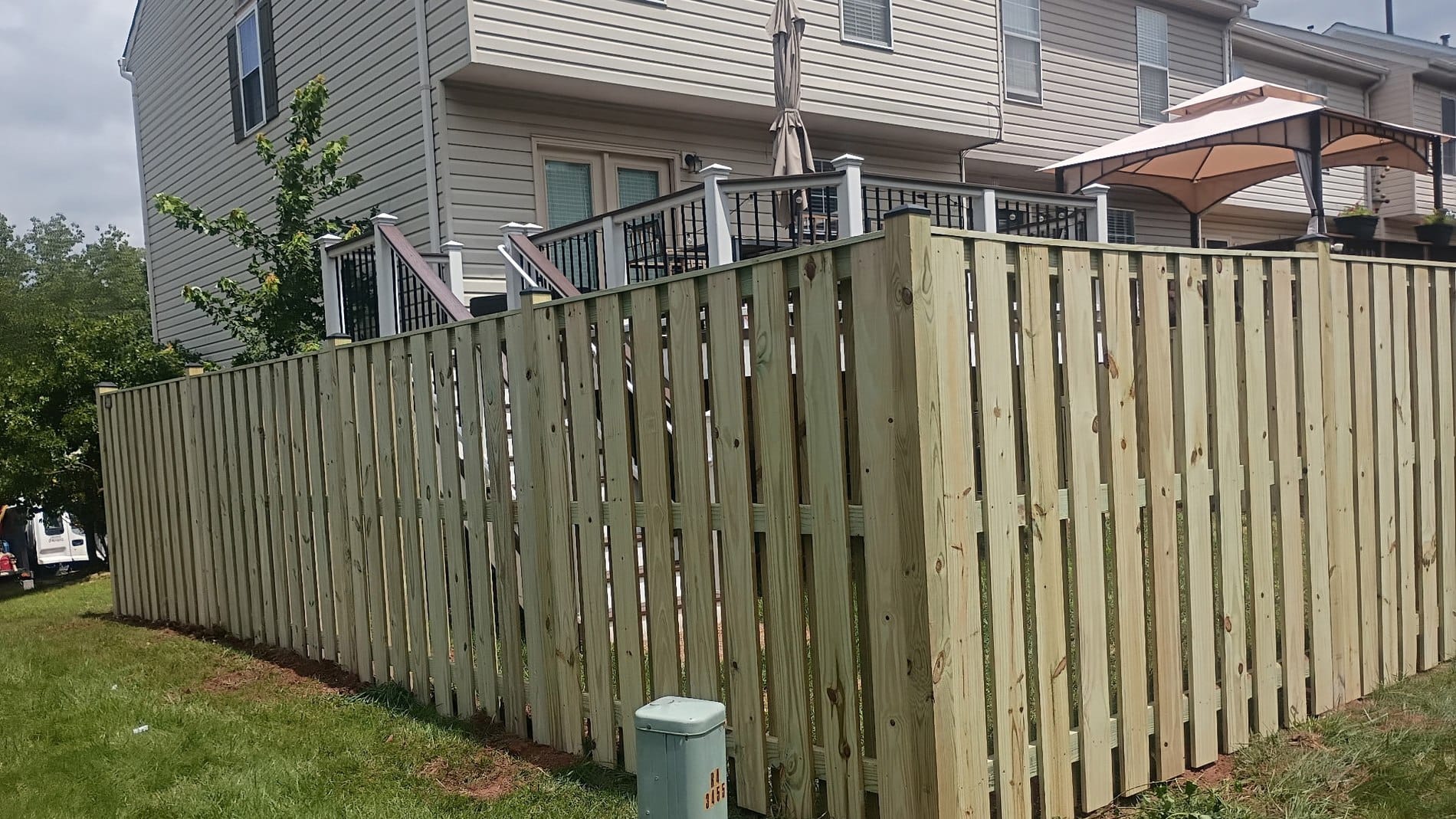 Wood privacy fence wrapping a back yard corner beside a deck