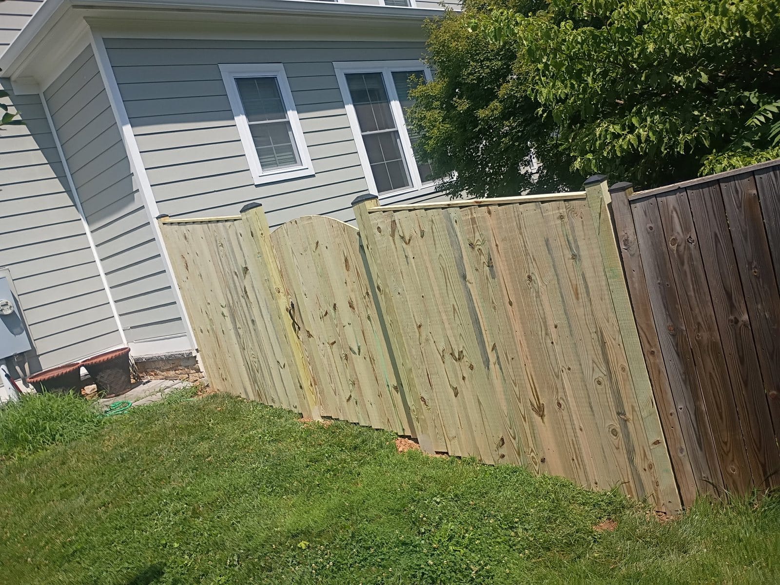 New wood fence section built alongside an existing older fence